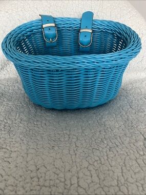 Kids Blue Woven Bike Basket with Straps or hang on a porch rail with flowers.